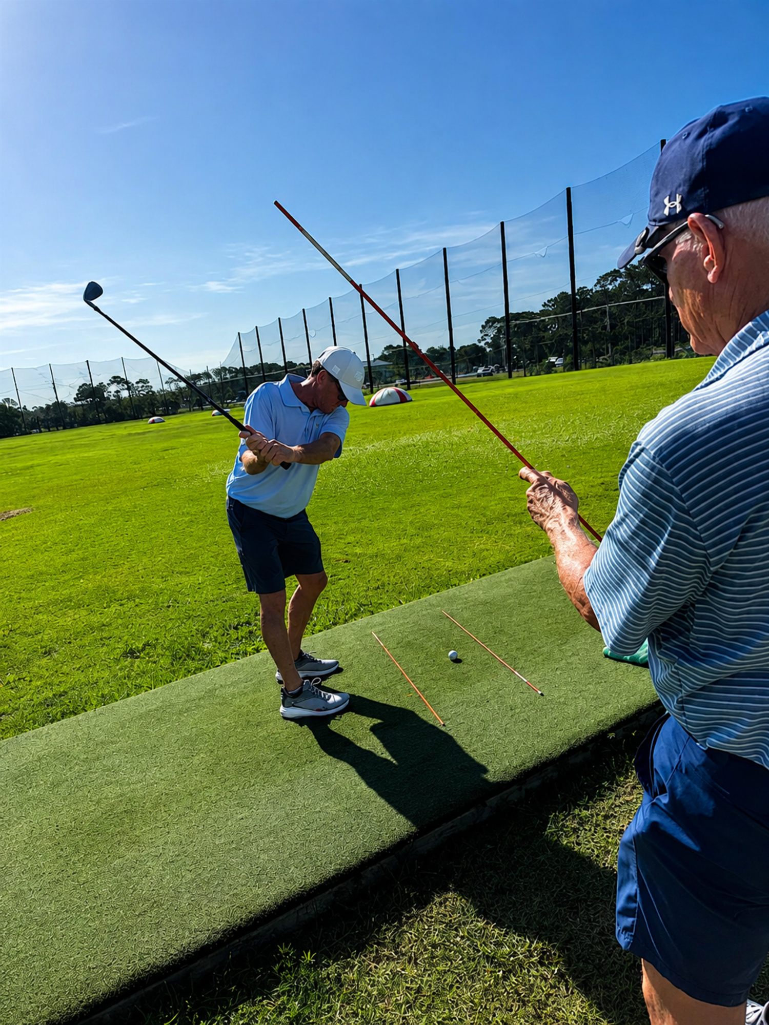 Rex Blair using alignment sticks during a golf lesson